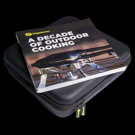 Ridge Monkey outdoor cooking book on a black protective case, celebrating a decade of outdoor culinary experiences.
